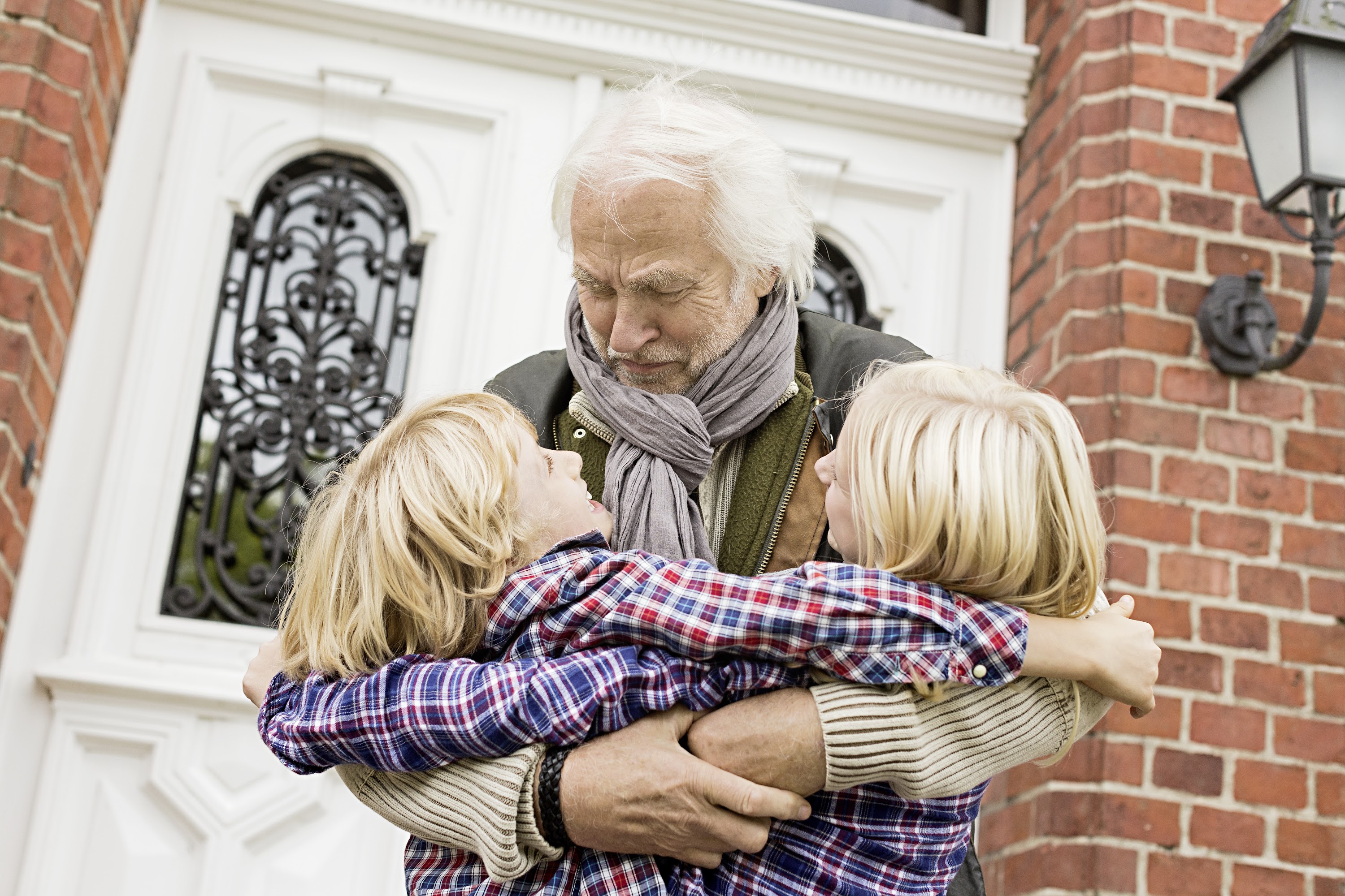 grandfather-hugging-grandchildren-by-front-door-2024-10-18-09-01-11-utc.jpg