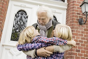 grandfather-hugging-grandchildren-by-front-door-2024-10-18-09-01-11-utc.jpg