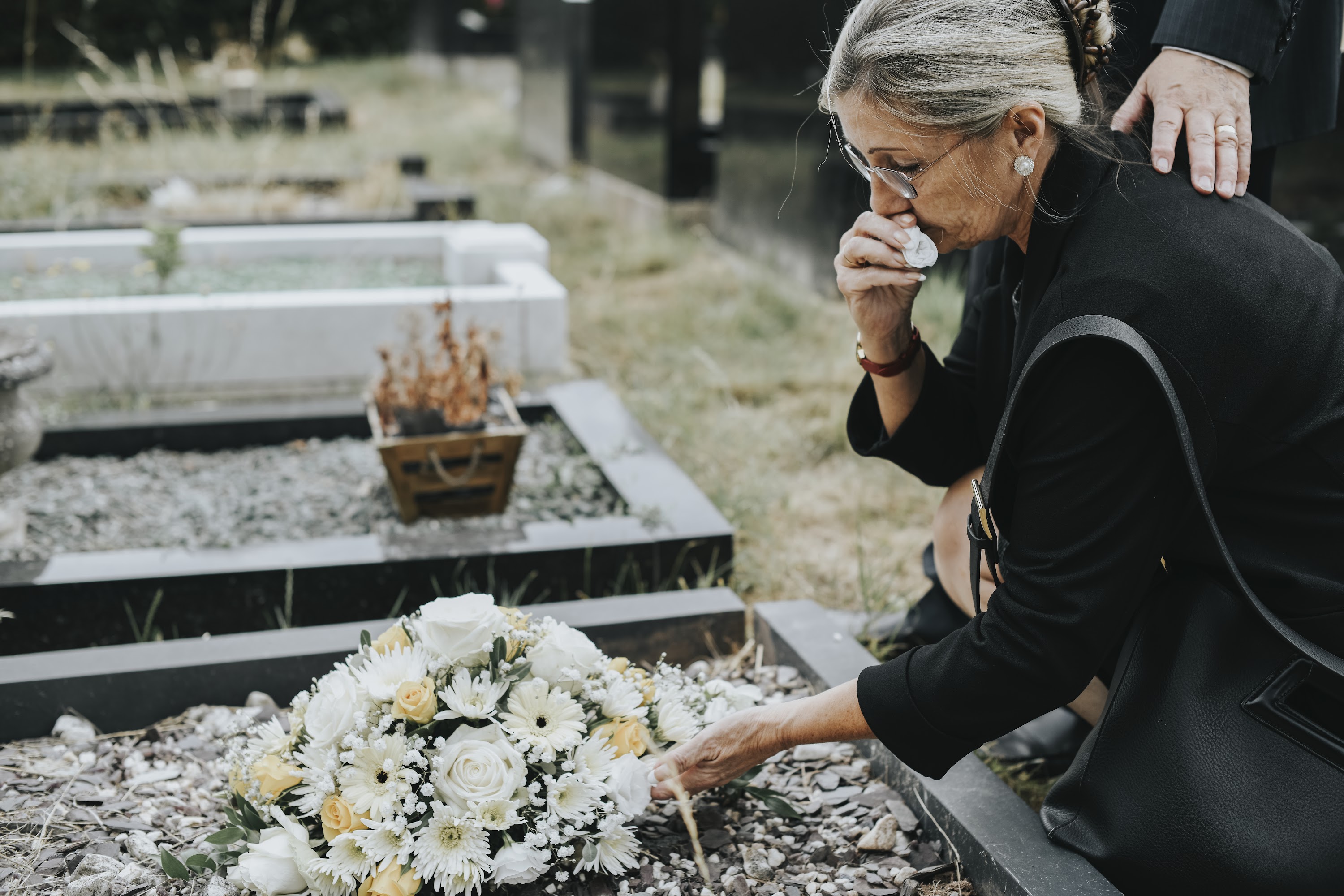 old-woman-laying-flowers-on-a-grave-2025-02-10-01-32-22-utc.jpg