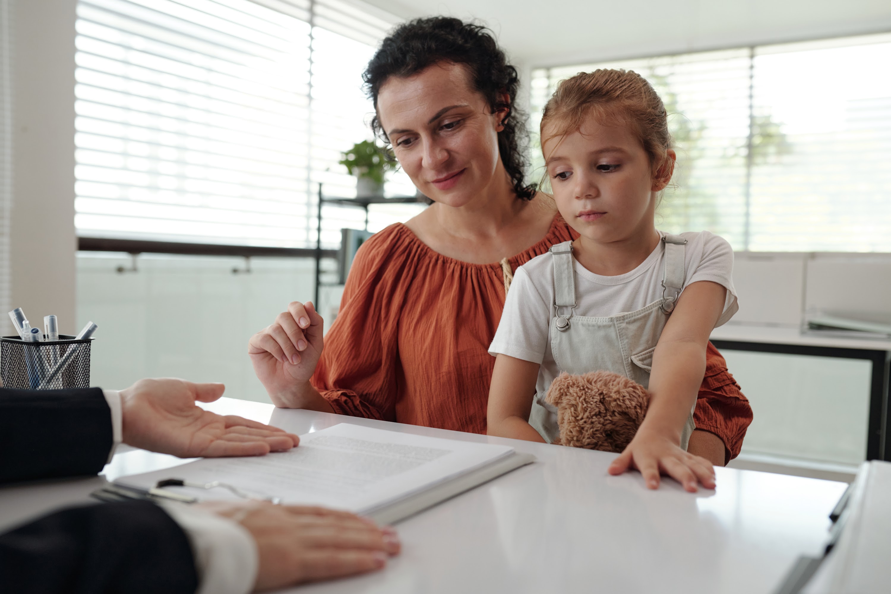 young-mother-signing-application-at-social-service-2025-01-29-14-49-29-utc.jpg