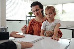 young-mother-signing-application-at-social-service-2025-01-29-14-49-29-utc.jpg