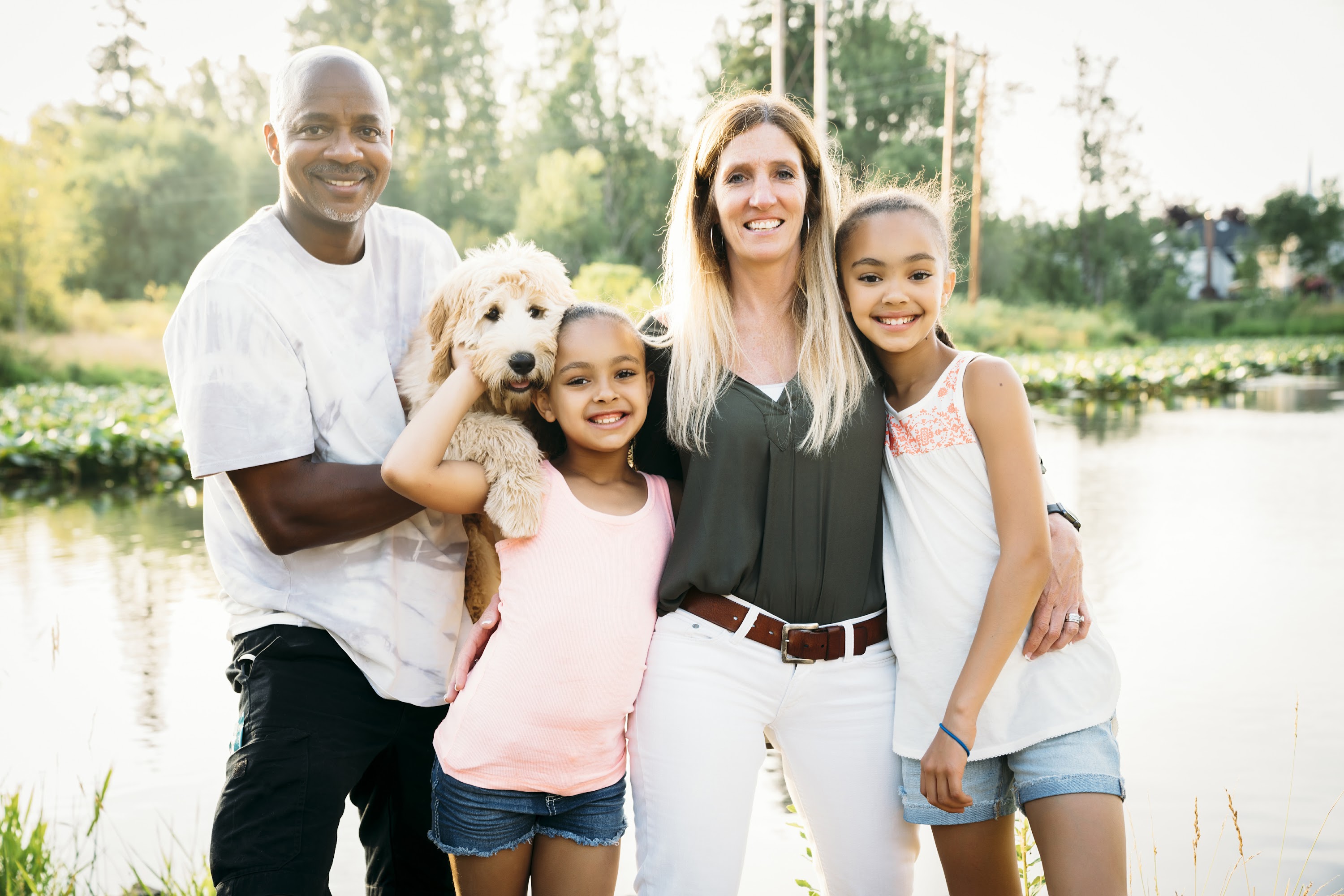 portrait-of-mixed-race-family-by-lake-with-labrado-2025-04-05-05-02-35-utc.jpg