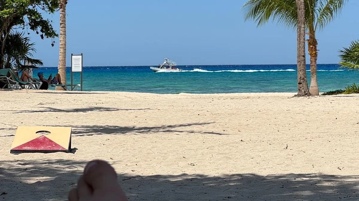 Relaxing beach scene in Cozumel with turquoise Caribbean water and a cornhole board on white sand