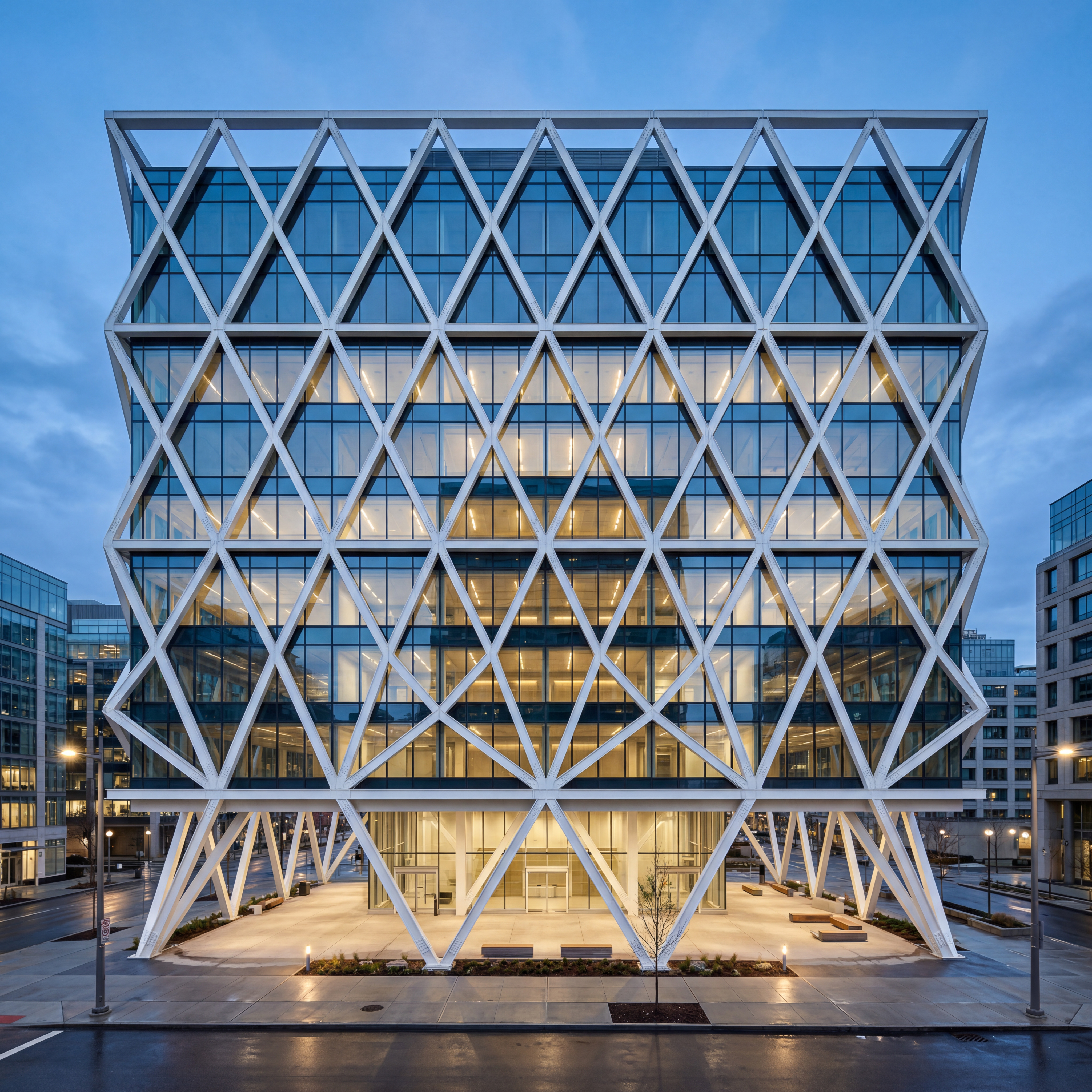 A modern architectural building with striking geometric triangular steel frames forming a repeating diamond pattern across the facade. The structure features large glass walls and open-air sections beneath, set in an urban setting during blue hour. Captured in a photorealistic style with clean lines and minimalist design, the white metal framework contrasts against a soft blue sky. The perspective is straight on at eye level emphasizing symmetry and balance, with a wide shot capturing the entire facade. Natural lighting with soft shadows enhances the intricate metal textures and detailed architecture, high resolution, sharp focus, modern architecture, urban environment, no people.