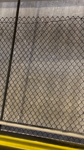 A video of snow falling in the narrow gap between sections of a parking deck